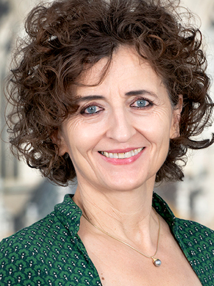 Image of woman with brown hair wearing a green blouse